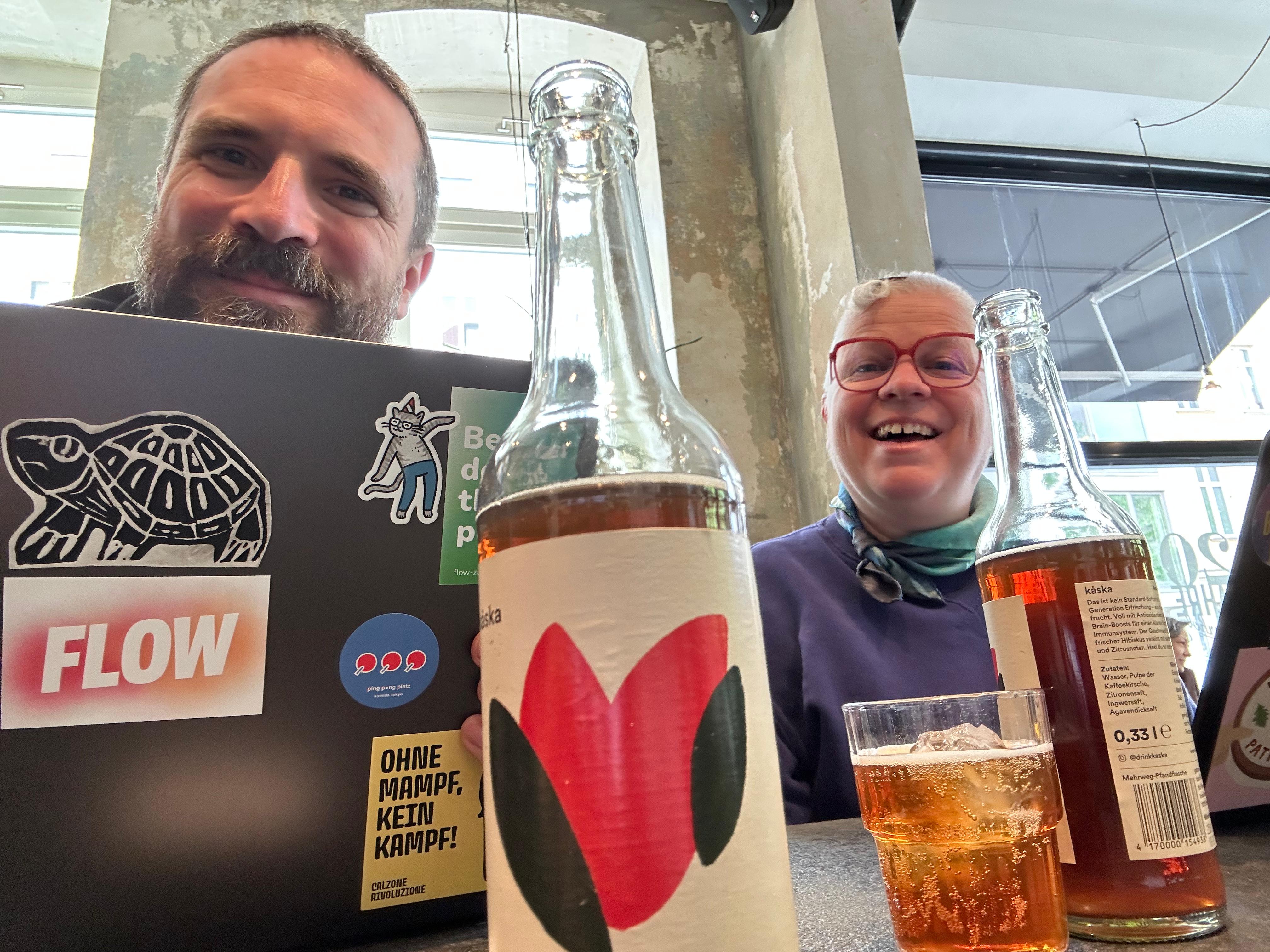 Nadja und ein Kollege mit einem Flow-Sticker am Laptop